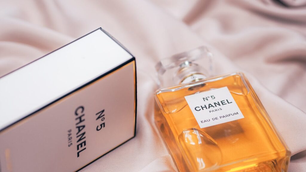 Close-up of Chanel No.5 perfume bottle and box on a soft fabric in Paris.