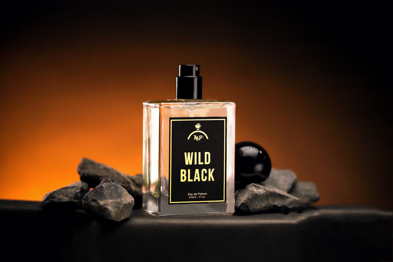 Luxurious Wild Black perfume bottle with bold, dramatic lighting on rock stones.